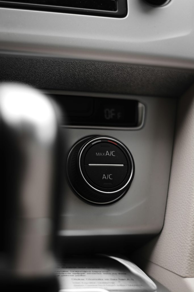 Vertical close-up shot of a car air conditioning control dial, highlighting the dashboard interface.